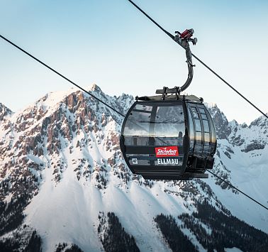 Blick auf Kabine der Hartkaiserbahn vor schneebedeckten Berggipfeln