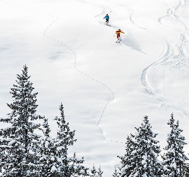 Blick von oben auf zwei Skifahrere im Tiefschnee