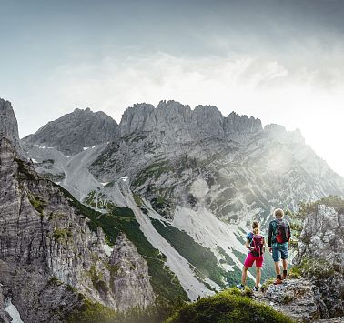 Zwei Personen die vor einem Berg stehen